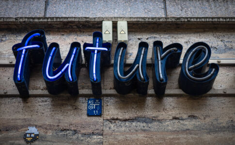 Blaue Neon-Schrift „future“ an einer verwitterten Hauswand, mit sichtbaren Kabeln und Gebrauchsspuren. Nur die Buchstaben 'fut' leuchten hellblau
